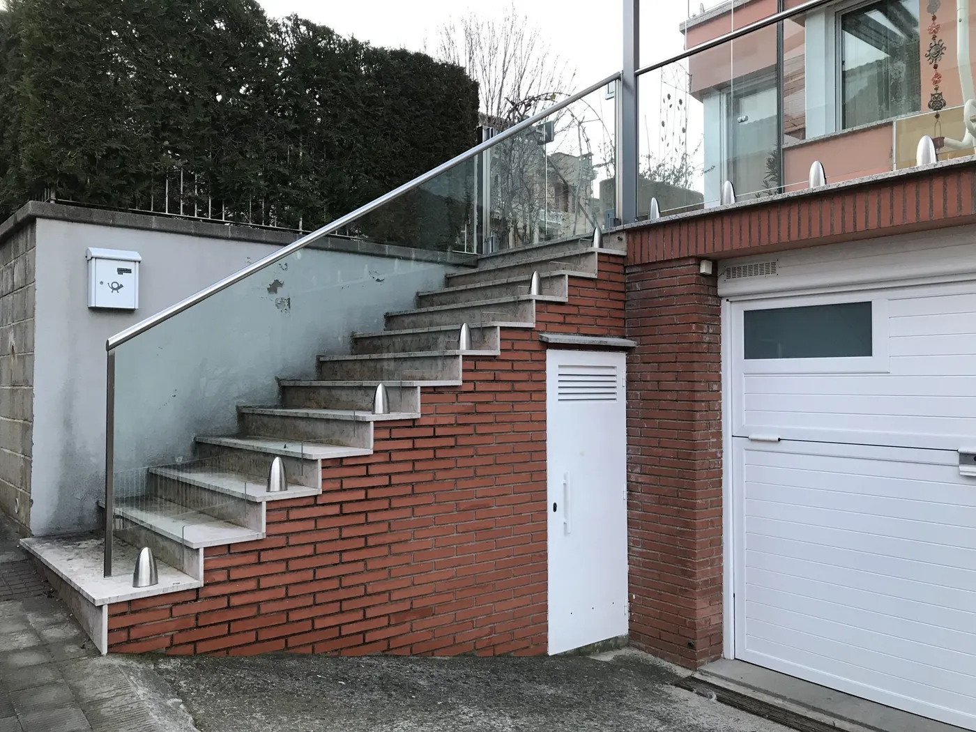 Dues portes de garatge seccionals blanques al costat d'una escala