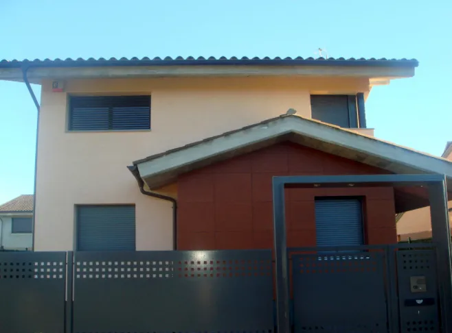 Habitatge amb tanca i cancel·la d'alumini perforat