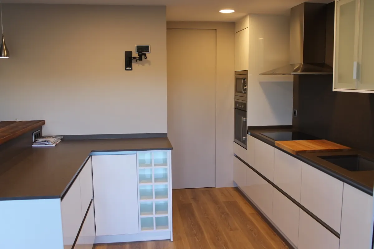 Cuina blanca a mida amb parquet i moble amb caixes vistes