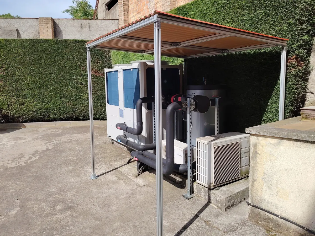 Bomba de calor aerotèrmica instal·lada sota una pèrgola metàl·lica, en una feina d'Instal Jet